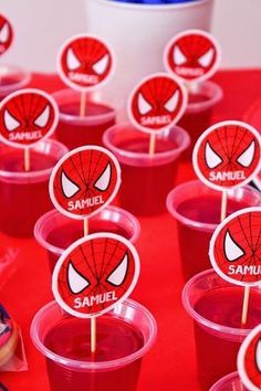 spiderman cupcakes are arranged in plastic cups