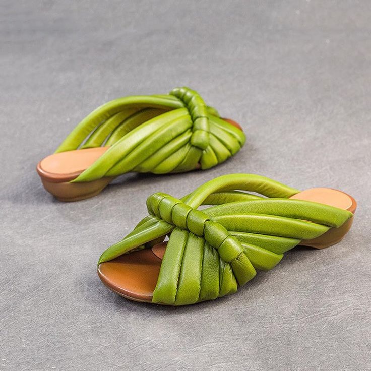 two pairs of green sandals with braided straps on the bottom and one has an orange sole