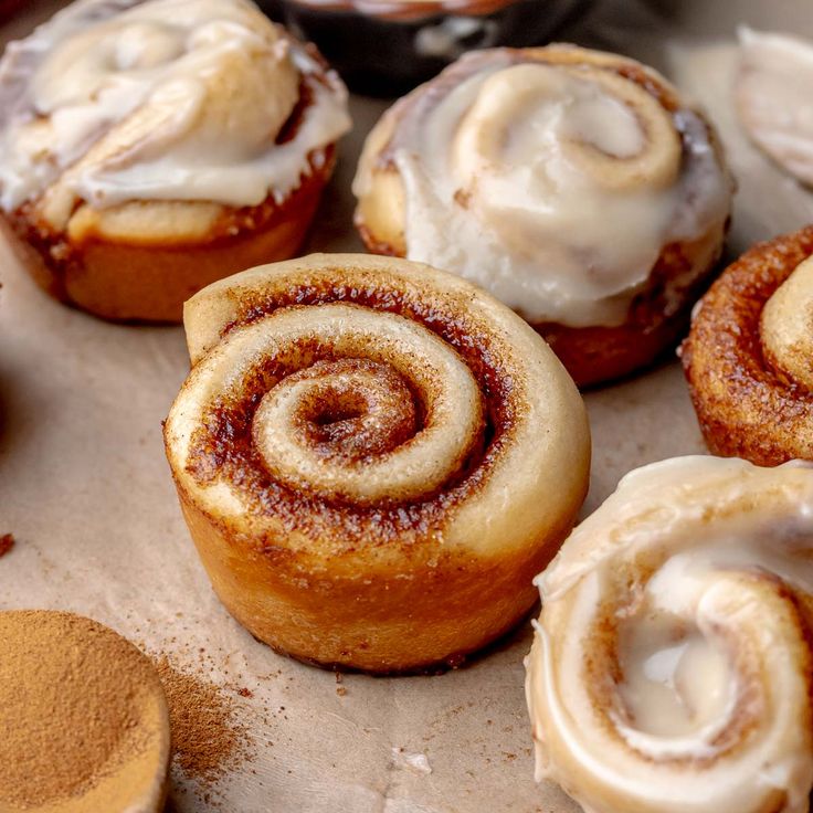 cinnamon rolls with icing sitting on top of a table