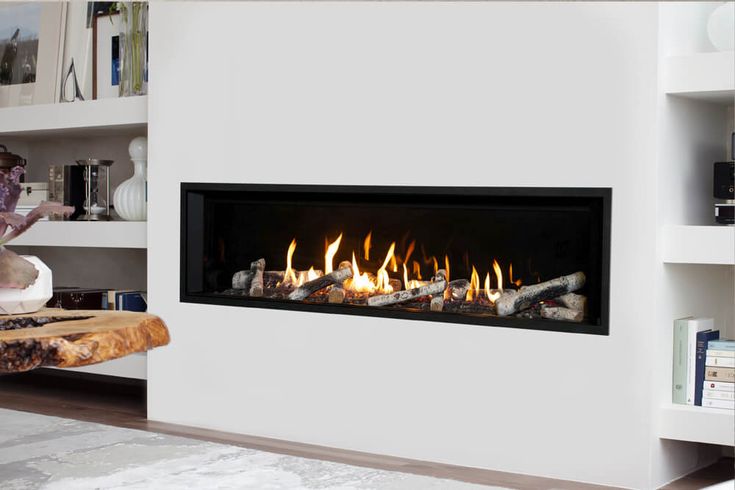 a modern fireplace with logs burning in it