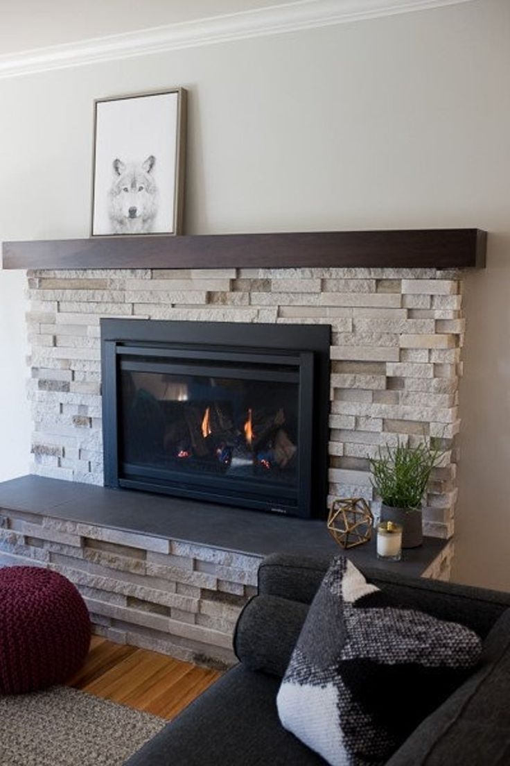 a living room with a fire place in the middle and a couch on the other side