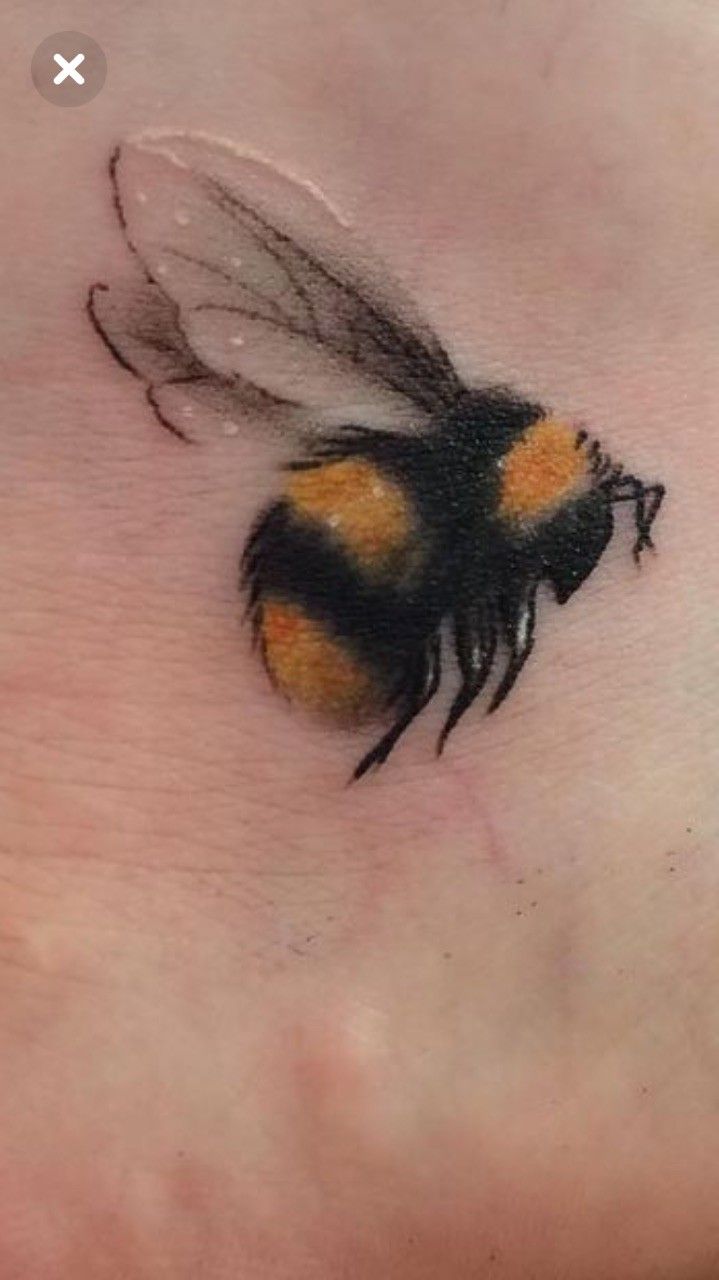 a small bee tattoo on the foot