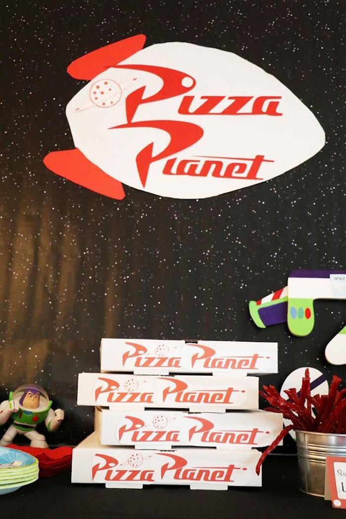 there is a pizza planet sign on the wall next to some boxes and other items