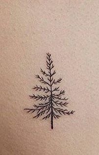 a small pine tree tattoo on the upper arm