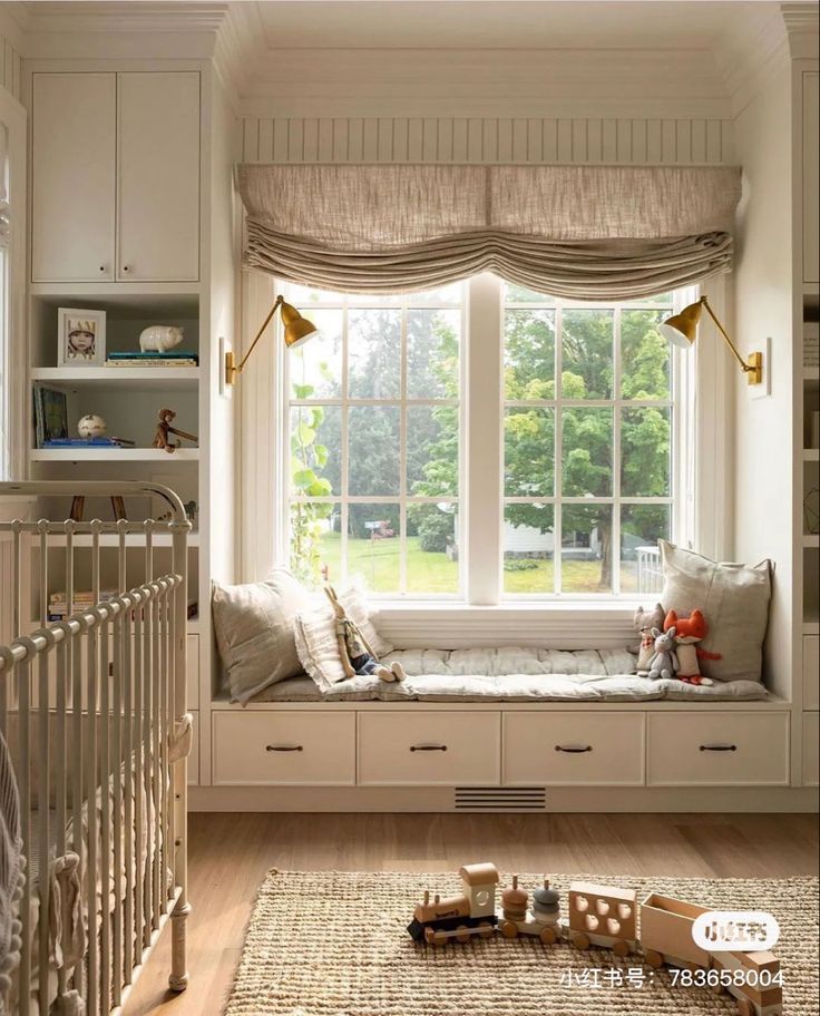 a baby's room with a crib, window seat and toys on the floor