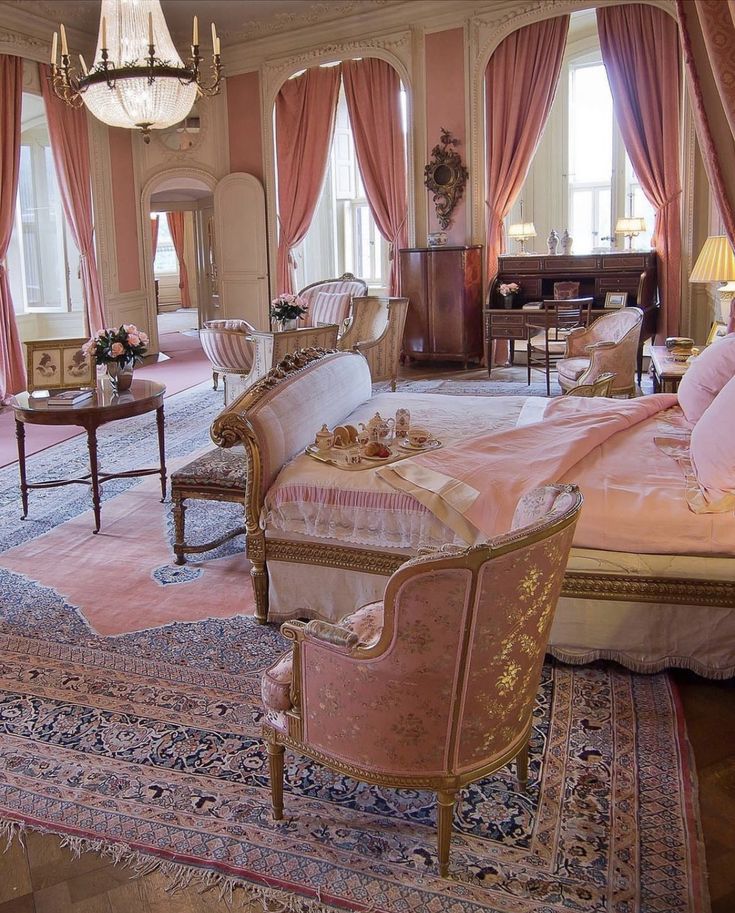 an ornate bedroom with pink walls and curtains on the windowsills is furnished with antique furniture