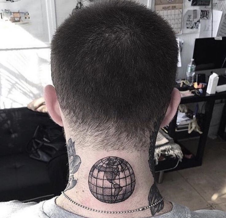 a man with a tattoo on his neck has a world globe tattooed on the back of his head