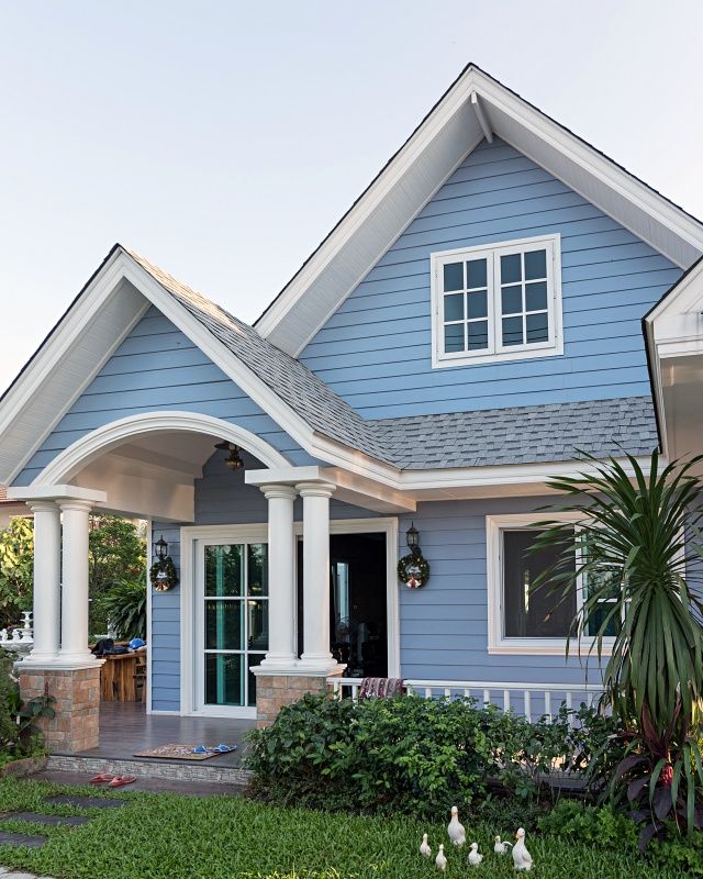 a blue house with white trim and columns