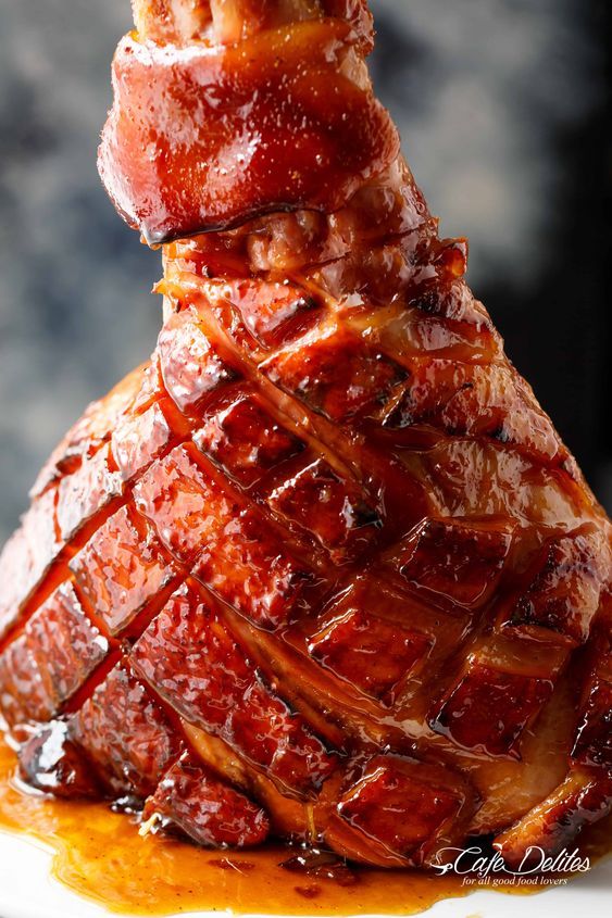 a large piece of meat sitting on top of a white plate covered in sauce and ketchup