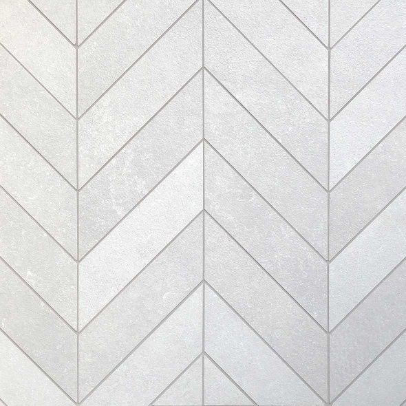 a white tile wall with an arrow pattern on it