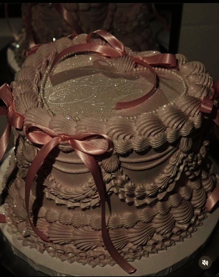 there is a large chocolate cake with pink ribbons on the top and bottom tiers