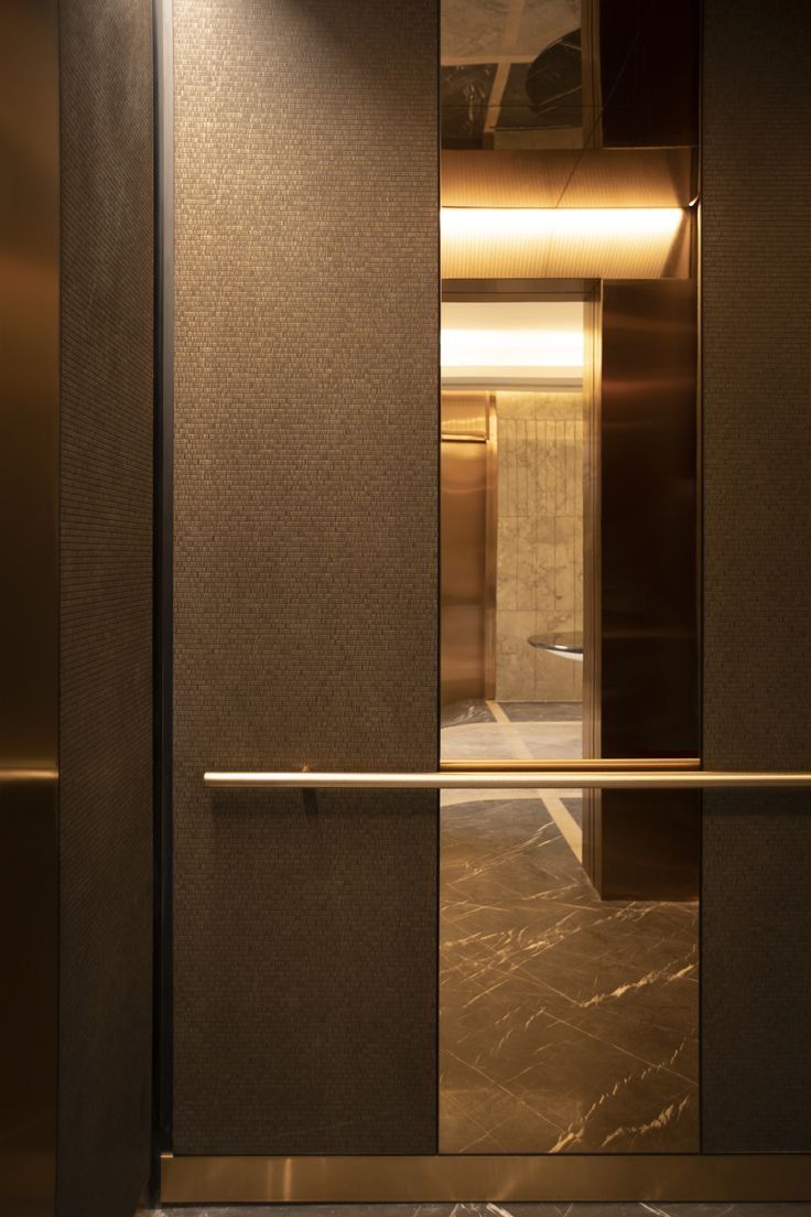 an elevator with glass doors and marble flooring