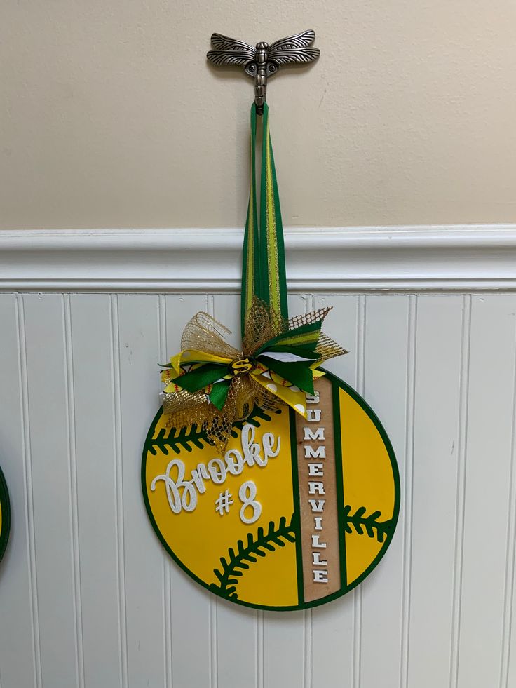 two sports themed plaques hang on the wall in front of a white paneled wall