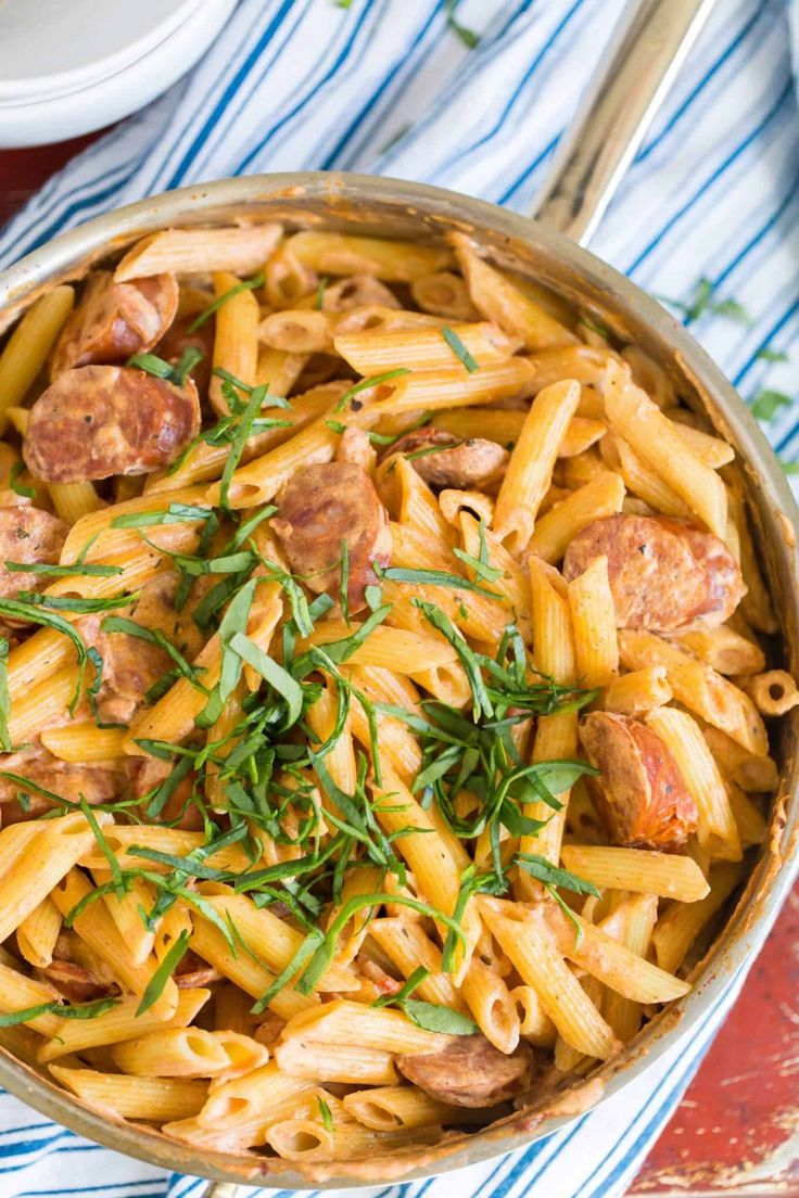 a pan filled with pasta and sausage on top of a table