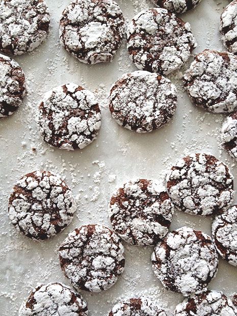 several cookies covered in powdered sugar sitting on top of a white countertop next to each other