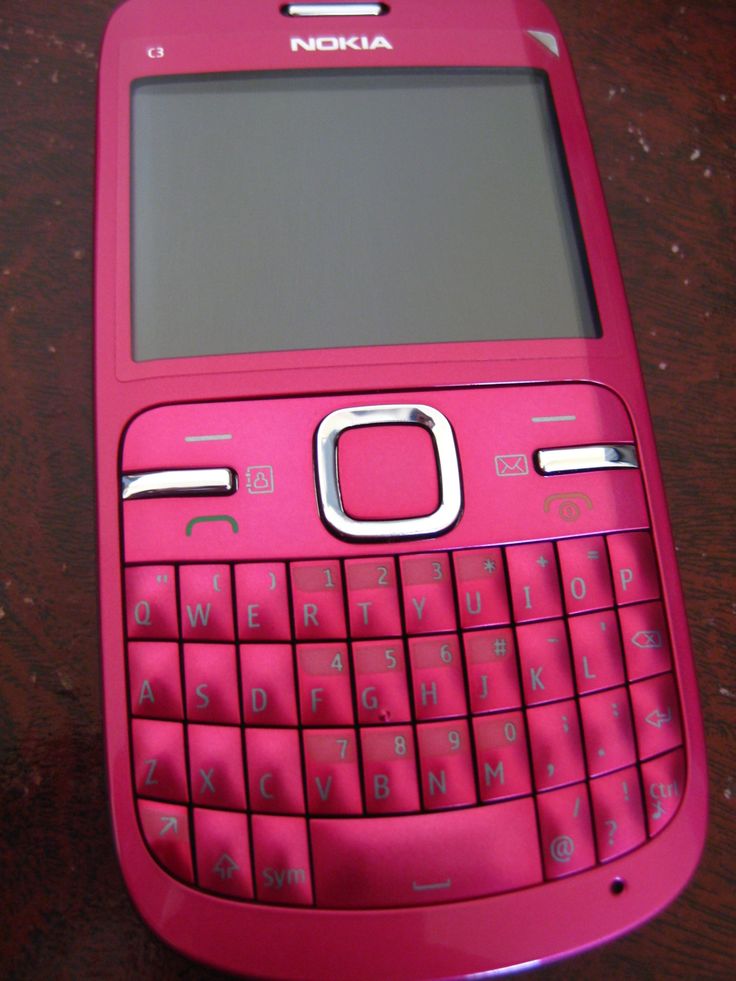 a pink nokia cell phone sitting on top of a wooden table