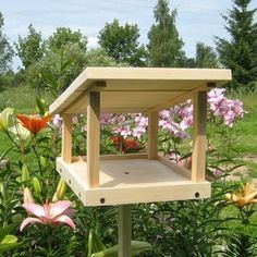 a bird house in the middle of some flowers