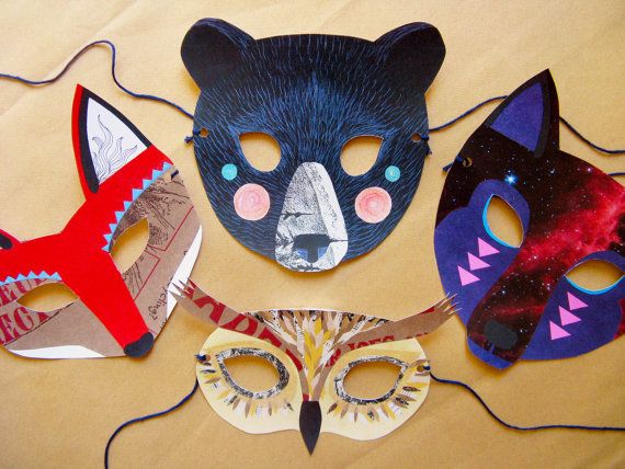 four masks are sitting on a table with paper machs in the shape of animals