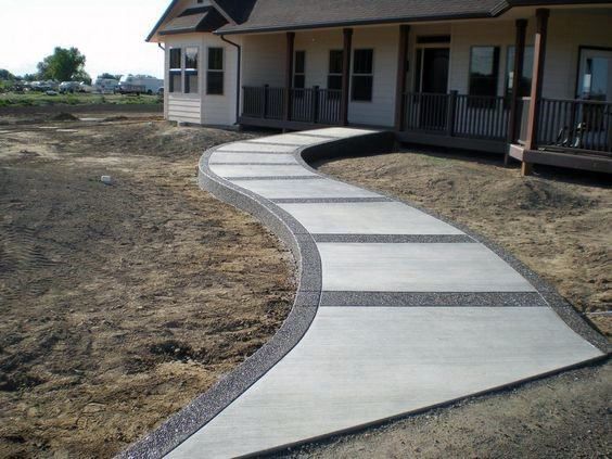 a concrete walkway in front of a house