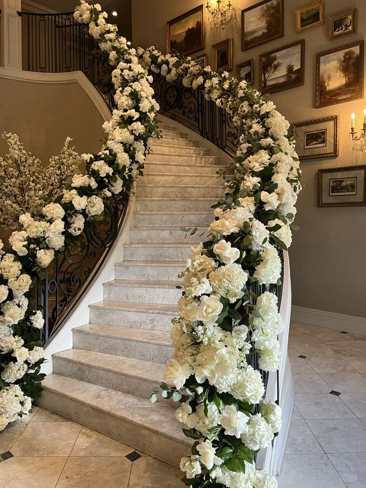 a bunch of flowers that are sitting on the side of a stair case next to a set of stairs