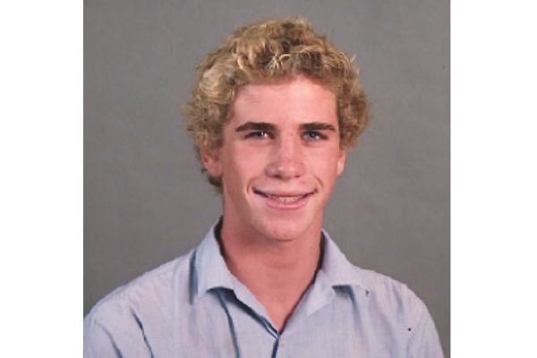 a young man with blonde hair smiling at the camera