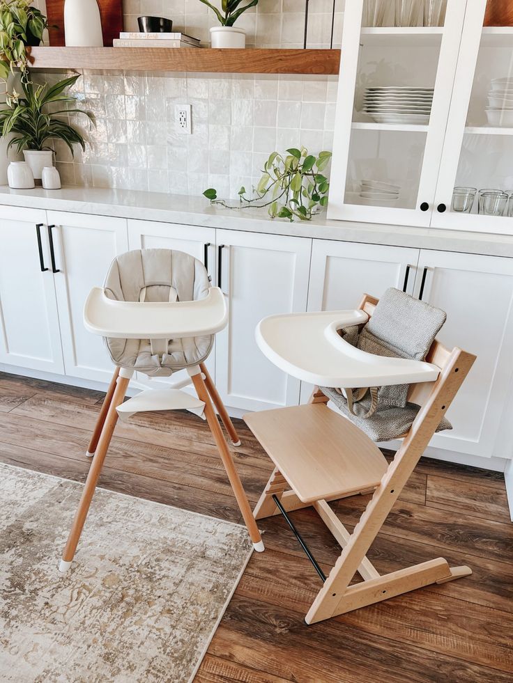 two baby highchairs sitting in a kitchen next to a table with chairs on it