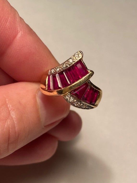 "Stunning art deco 14K synthetic Ruby and natural earth-mined Diamond Bypass wide band Ring. the ring is a size 6.5 and weighs 5 grams. The face measures 5/8\" tall at the widest measurement. Nine 5mm x 3mm tapered baguette rubies in open back channel setting with eight pave set round cut diamonds. Marked 14K, GA. Excellent condition. The stones are an intense red to fuchsia." Anniversary Jewelry With Baguette Diamonds And Ruby, Red Baguette Diamond Rings For Anniversaries, Red Baguette Diamond Rings For Anniversary, Luxury Baguette Cut Ruby Ring, Ruby Rings With Baguette Diamonds For Anniversary, Ruby Jewelry With Baguette Diamonds For Anniversary, Anniversary Ruby Ring With Baguette Diamonds, Gold Ruby Ring With Baguette Diamonds For Anniversary, Anniversary Ruby Rings With Baguette Diamonds