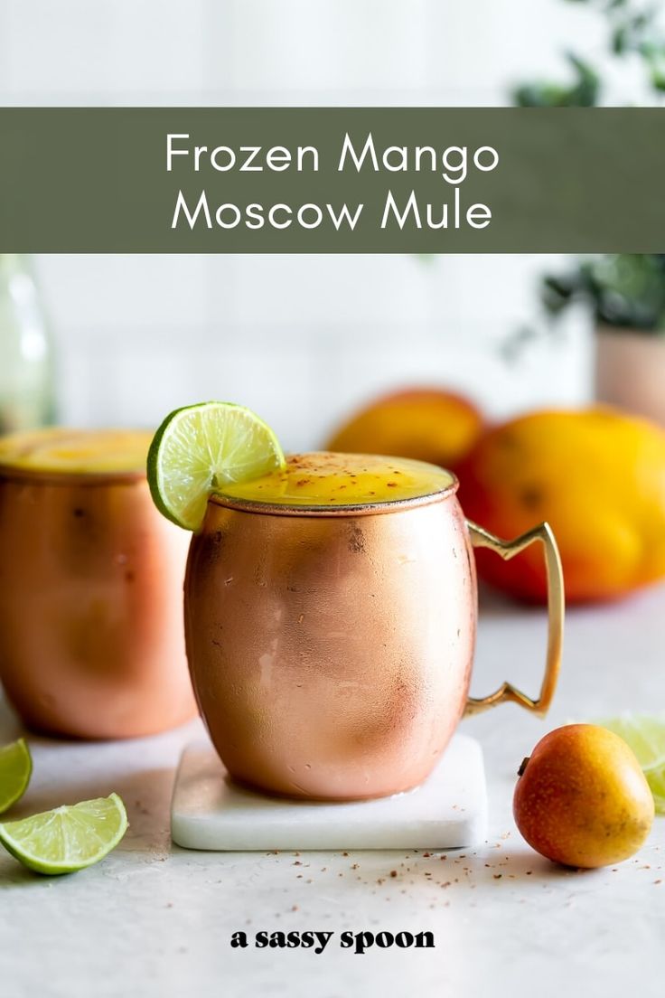 two copper mugs filled with frozen mango moscow mules and garnished with lime