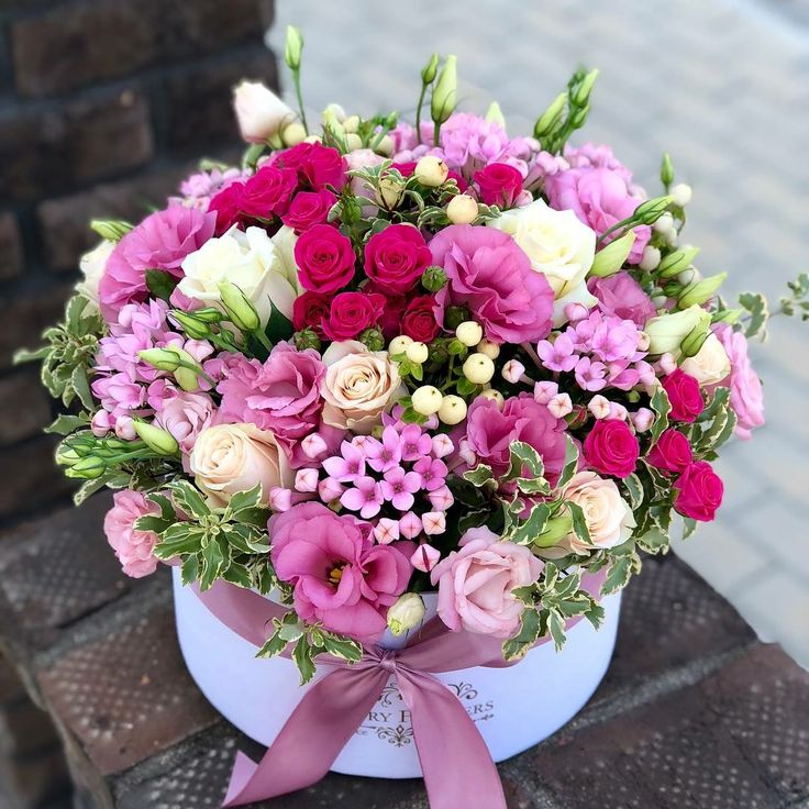 a bouquet of pink and white flowers in a bucket