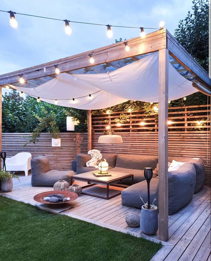 an outdoor living area is lit up with string lights