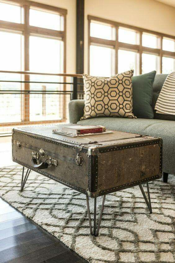 an old trunk is sitting on the floor in front of a couch and coffee table