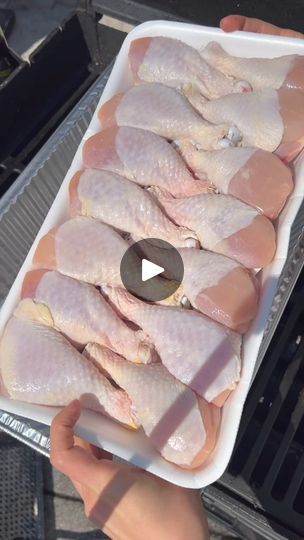 someone is holding a tray with raw chicken on it, and the video shows how to cook