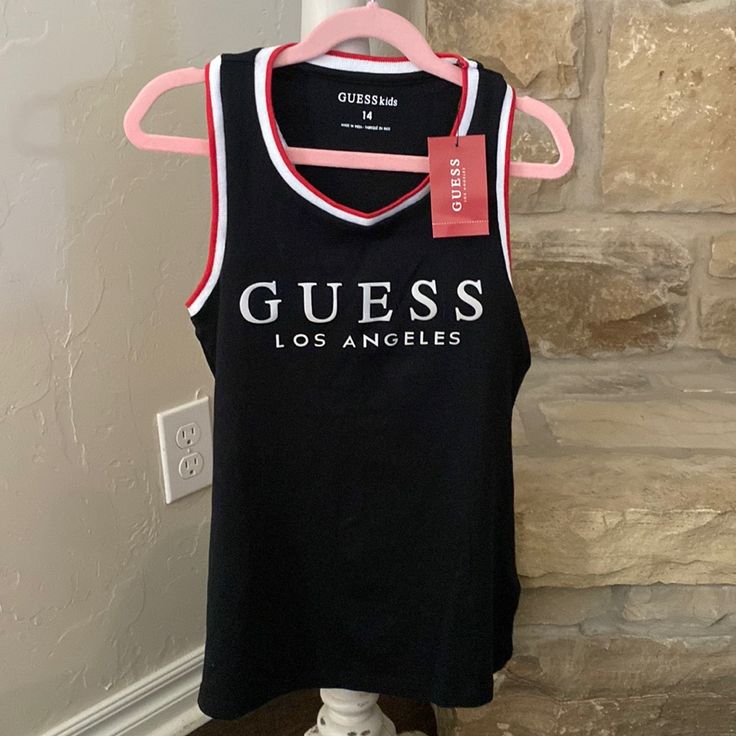 This Is A Brand New Guess Tank Top. Perfect For Summer Black Cotton Tank Top With Logo Print, Black Sleeveless Top With Letter Print, Black Logo Print Tank Top For Summer, Black Crew Neck Tank Top With Letter Print, Black Cotton Tank Top With Letter Print, Stretch Black Tops With Logo Print, Black Stretch Top With Logo Print, Girls Cuts, Guess Girl