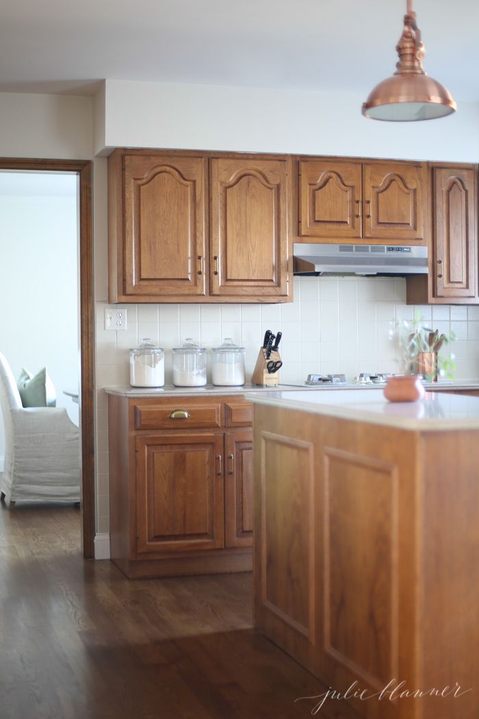 a kitchen with wooden cabinets and white walls