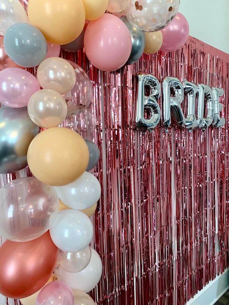 balloons and streamers decorate the entrance to a bridal party in pink, silver and gold