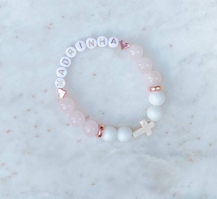 This beautiful personalized beaded bracelet is made with Rose Quartz ( Pink), Aquamarine (Blue) or Alabaster (White),  Howlite Cross and copper beads.   These bracelets are the perfect addition for your special occasion as a favour for a baptism, christening, communion, wedding shower, confirmation or any special or religious occasion.   DETAILS: ♡ Each bracelet comes with letter beads, 10 to 12 - 10MM beads and a Howlite Cross.  ♡ Select bracelet size in drop down.  Custom sizes available, specify in personalization section.  Select size or measure your wrist and add between 1/4 to 1/2 inch depending on your preference. ♡ Made with White Alabaster and Aquamarine or Rose Quartz beads and copper details. ♡ Each bracelet comes packaged beautifully with a jewellery bag. Great as a favour or a Personalized Beaded Bracelets As Gifts, Personalized White Stretch Bracelet As Gift, Personalized Round Beads Bracelets For Birthday Gift, Personalized White Beaded Bracelets As Gift, Customizable Pink Bracelets For Mother's Day, Personalized White Beaded Bracelets Gift, Customizable Round Beads Bracelets For Gift, Customizable Round Beads Bracelet As A Gift, Customizable White Bracelets For Birthday