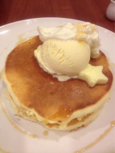 a white plate topped with pancakes covered in syrup and ice cream