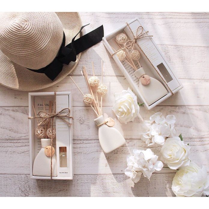 a hat, perfume bottle and flowers on a table