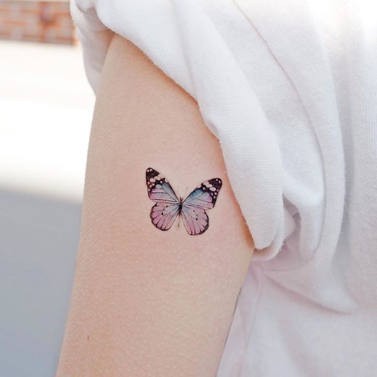 a woman's arm with a butterfly tattoo on the left side of her arm