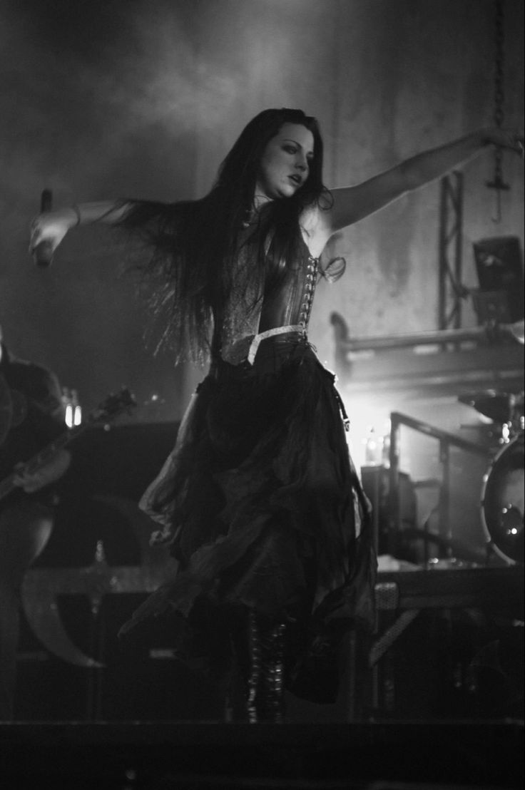 a woman with long hair is dancing on stage