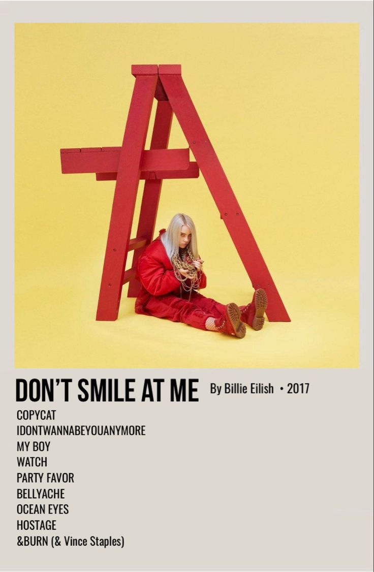 a woman laying on the ground next to a red wooden structure that says, don't smile at me 2011