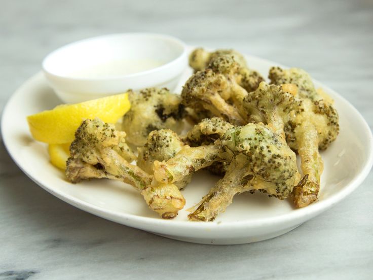 broccoli florets on a white plate with dipping sauce