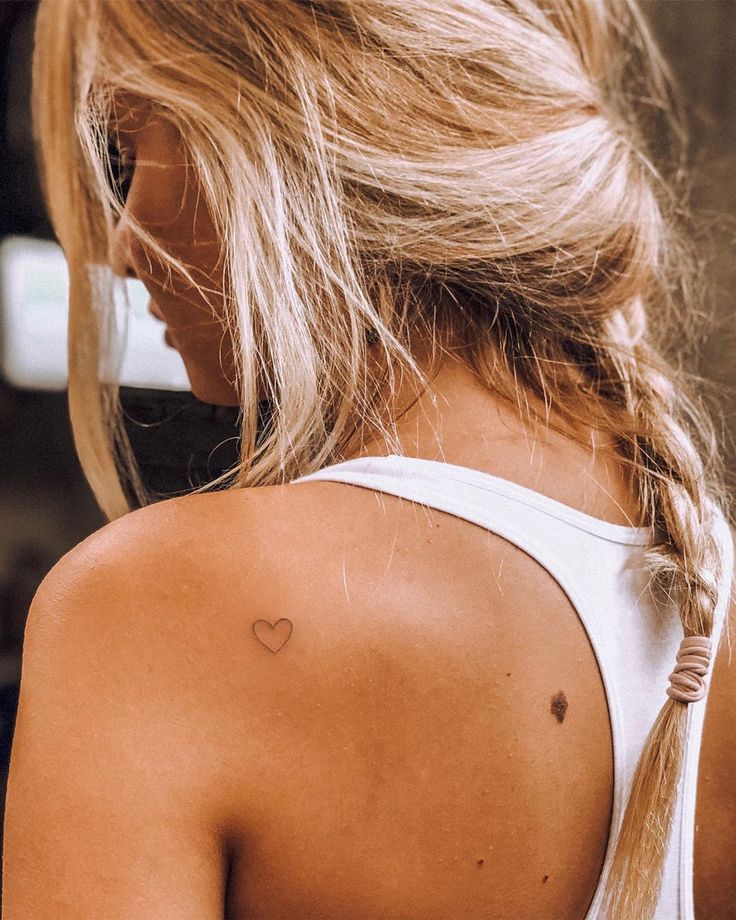 a woman with a heart tattoo on her back