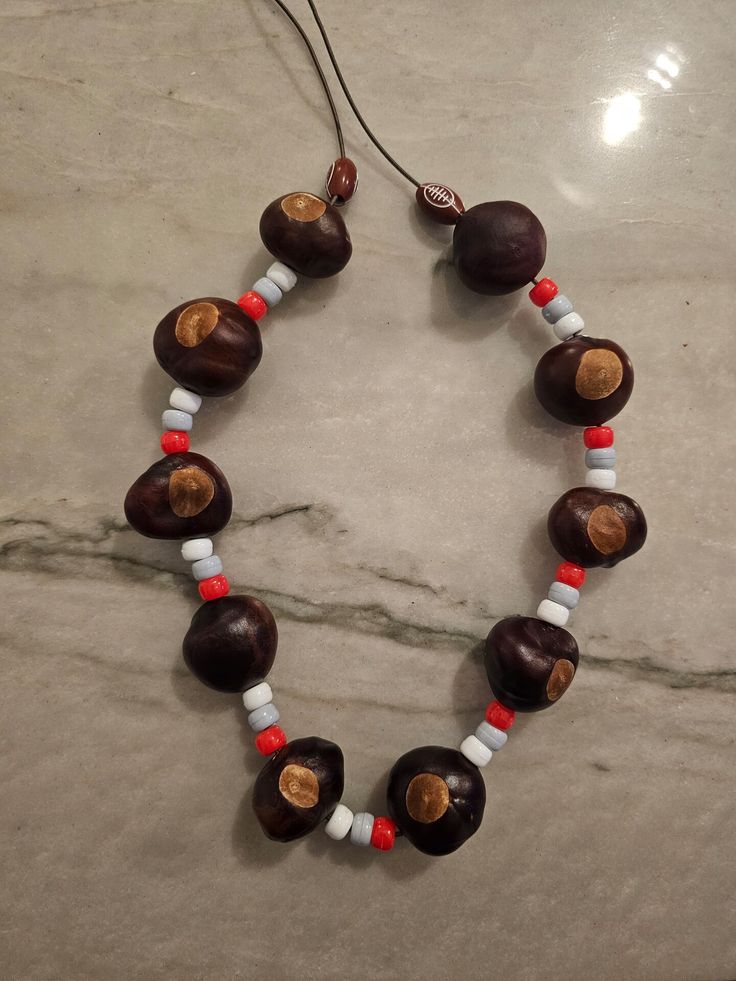 a brown and white beaded necklace on a marble surface