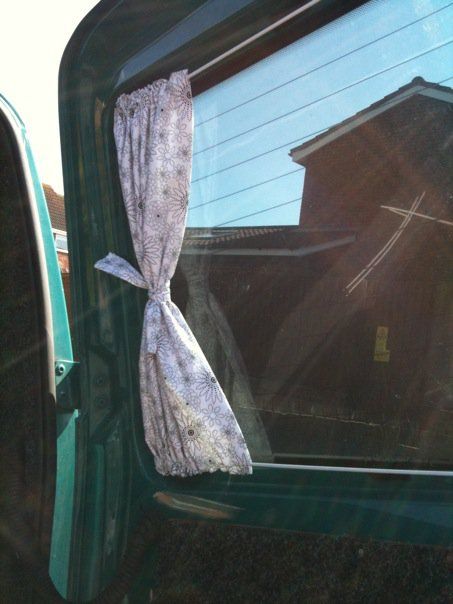 the curtain is hanging on the side of the truck door, and it's still attached to the window