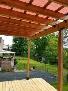 a wooden deck with a hot tub on top of it in front of a house