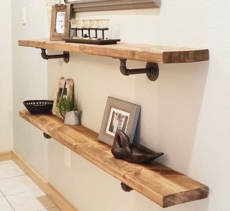 two wooden shelves on the wall with pictures and other items sitting on top of them