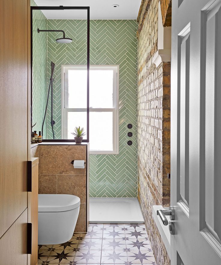 a bathroom with green and white tiles on the walls