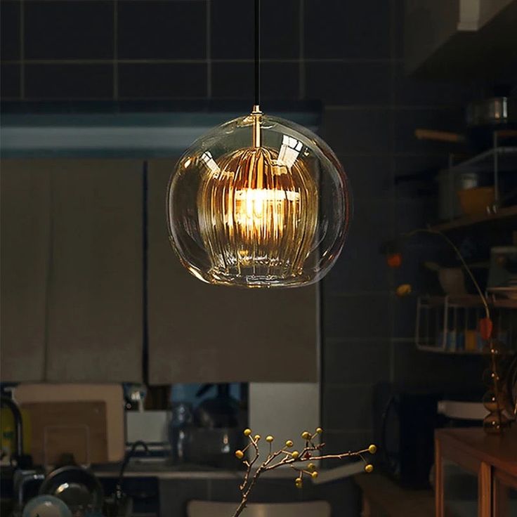 a kitchen filled with lots of counter top space and a light hanging from the ceiling