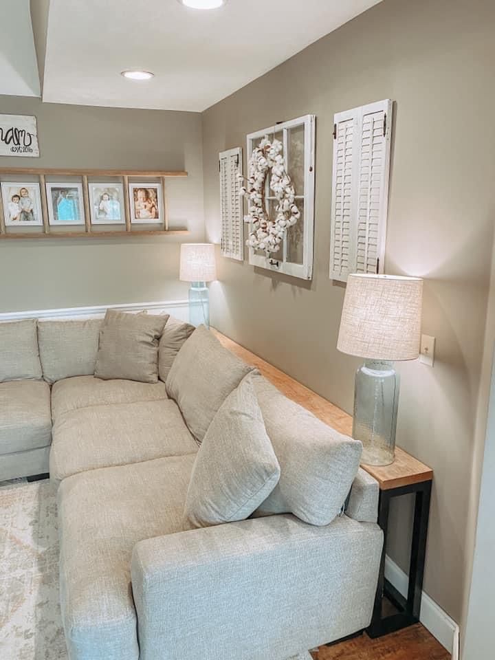 a living room filled with furniture and framed pictures on the wall above it's couch